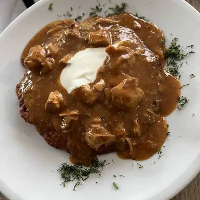 Placek ziemniaczany z gulaszem i kleksem śmietany
